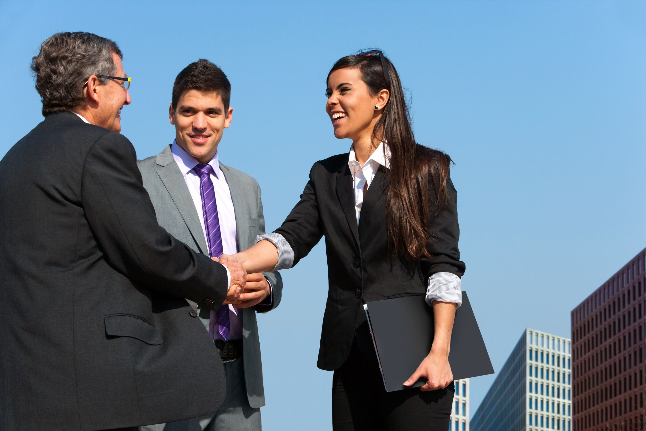 13686659 – young business couple shaking hands with partner outdoors.